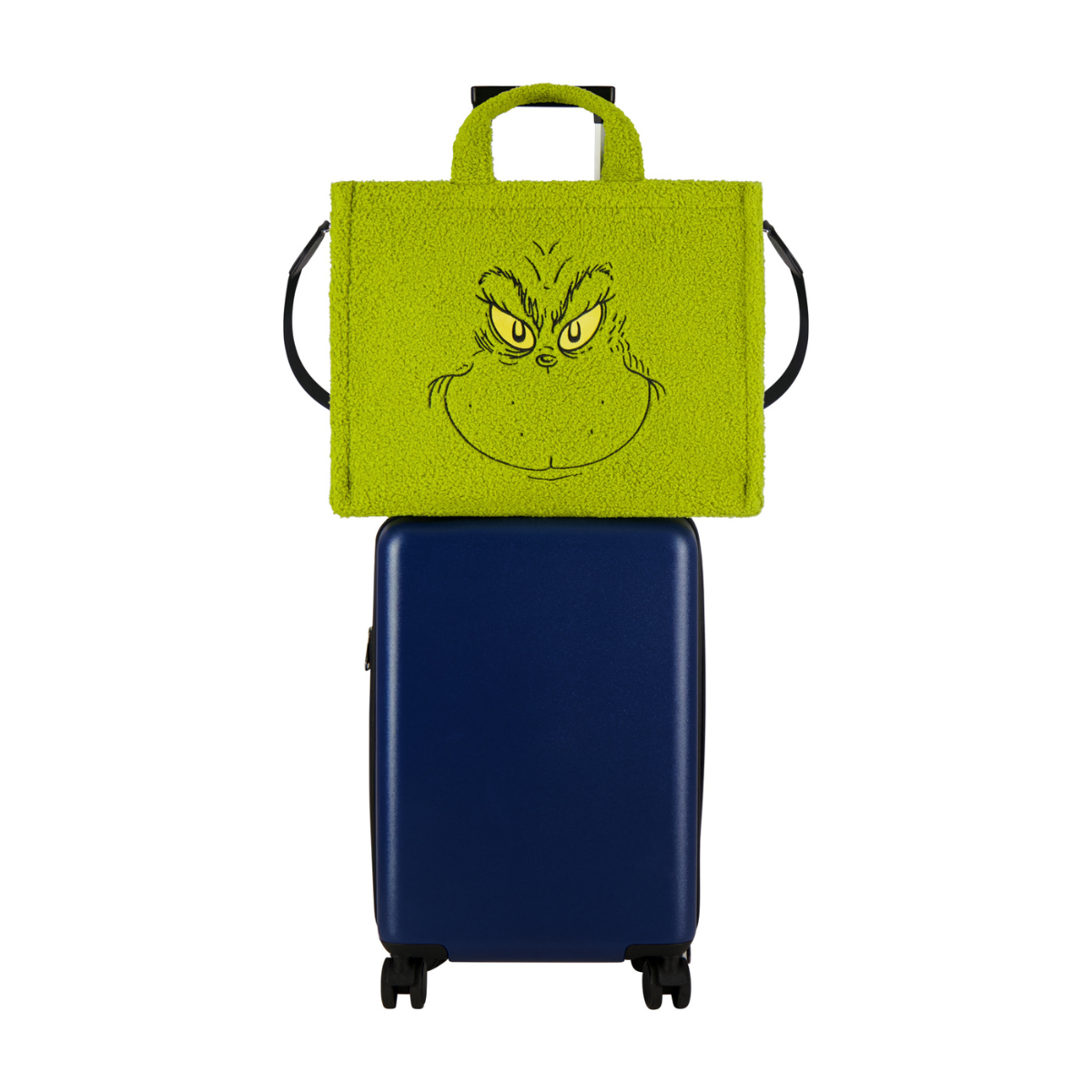 Dr. Seuss green Grinch big face sherpa travel tote with trolly band and adjustable removable shoulder strap on a luggage.